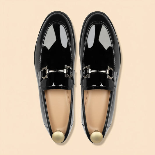 Pair of men's black patent leather horsebit loafers with silver buckle - top view